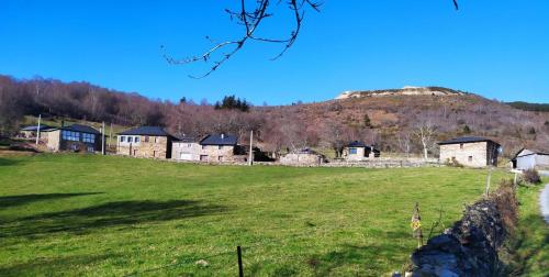 um campo com casas e uma colina ao fundo em O Busto Aldea Rural, Apartamento HORNO 2 