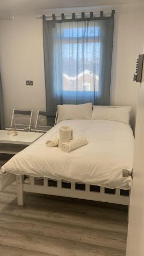 Una cama blanca con dos toallas encima. en Guest & Rest 14 en Londres