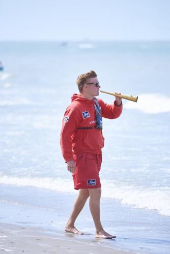 a man standing on the beach holding a stick at MOLO roof - stylish penthouse with marina view Blankenberge within walking distance from the sea - 15 km from Bruges in Blankenberge