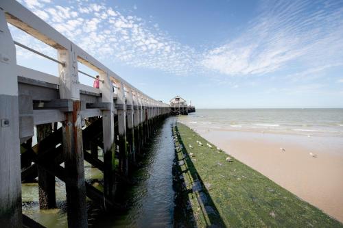 a pier on the beach next to the ocean at MOLO roof - stylish penthouse with marina view Blankenberge within walking distance from the sea - 15 km from Bruges in Blankenberge