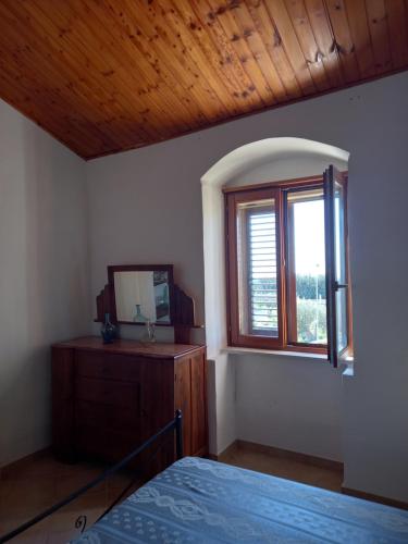 a bedroom with a bed and a mirror and a window at Scicli Città felice in Scicli