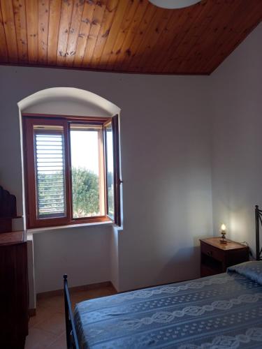 a bedroom with a bed and a window at Scicli Città felice in Scicli