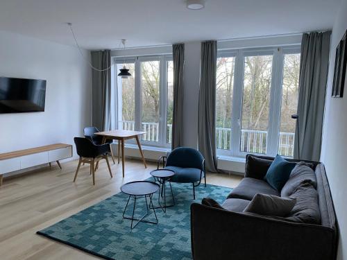 ein Wohnzimmer mit einem Sofa, Stühlen und einem Tisch in der Unterkunft Louis & Louise Apartments & Lofts Am Wall I Digital Check In in Bremen