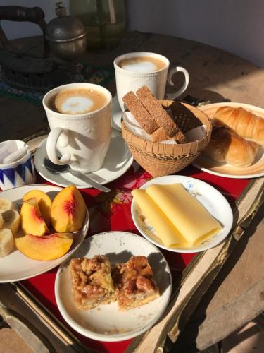 una mesa con platos de comida y tazas de café en Casita: “Granada” en San Antonio de Areco