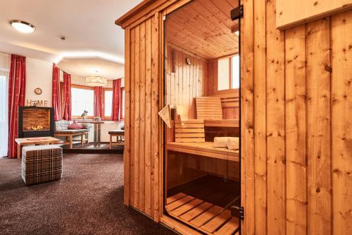 a room with a wooden cabin with a fireplace at Ferienhotel Jörglerhof in Hainzenberg