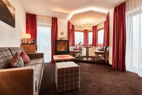 a living room with a couch and a fireplace at Ferienhotel Jörglerhof in Hainzenberg