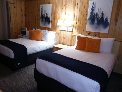 two beds in a room with wood paneling at Cliff Dweller on Lake Superior in Tofte