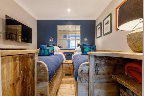 two beds in a room with blue walls at Marners Rock No 3 in Fowey