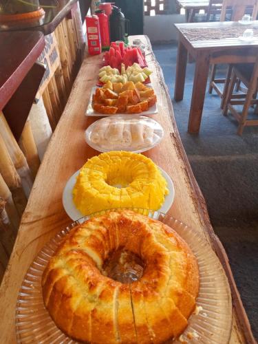 een tafel met taarten en gebak op borden bij Estresse Zero in Atins