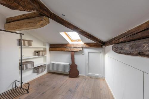 a room with wooden beams and a guitar on the wall at Italy prestigious historical attic in Bologna in Bologna