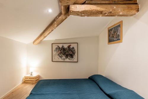 a bedroom with a blue bed and wooden ceilings at Italy prestigious historical attic in Bologna in Bologna