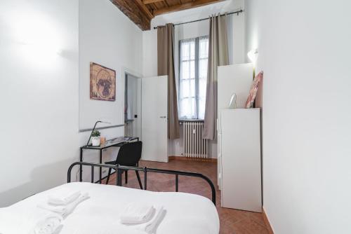 une chambre avec un lit et un bureau dans une pièce dans l'établissement House of Foscolo - Palazzo Cornazzani - by Host4U, à Pavia