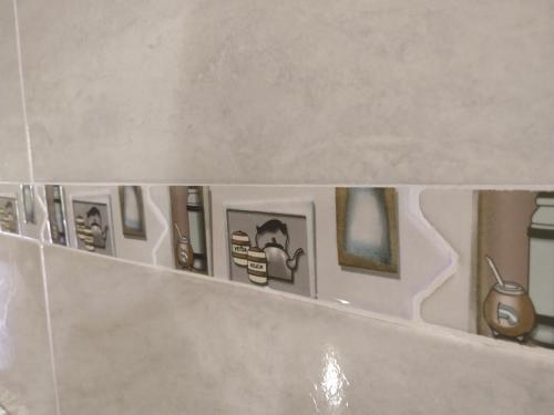 uma fila de fotografias numa prateleira na casa de banho em Lo de Chavela em Salta