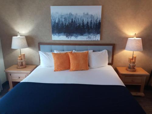 a bedroom with a large bed with two lamps at Cliff Dweller on Lake Superior in Tofte
