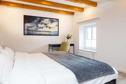 a bedroom with a white bed and a desk at stadtmauer apartments - Stilvolle Wohnung mit King Bett direkt an der historischen Stadtmauer in Nördlingen