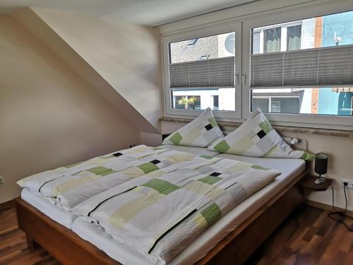 ein Bett in einem Schlafzimmer mit einem großen Fenster in der Unterkunft Haus Elisa in Helgoland