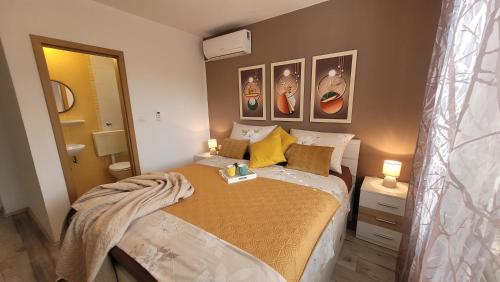 a small bedroom with a bed with yellow pillows at Katy in Krk