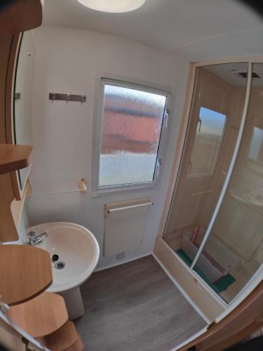 a small bathroom with a sink and a window at Blauwe Lagune in De Haan