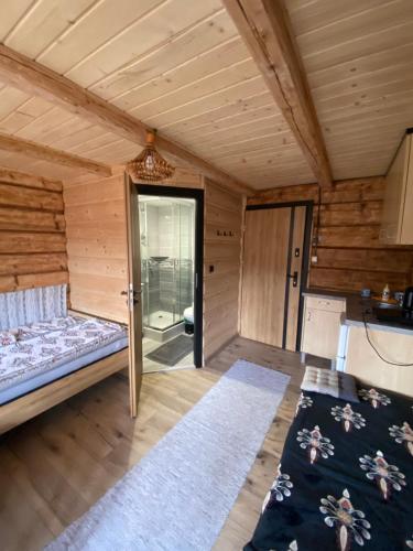 a room with a bed in a wooden cabin at U Hudoka in Sromowce Niżne