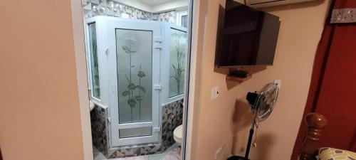 a bathroom with a glass shower with a toilet at Harmony Apartment in Loubiere
