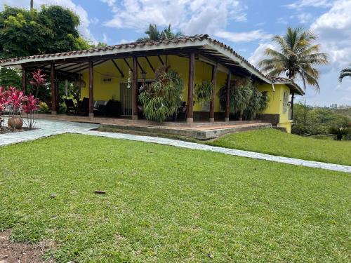 ein gelbes Haus mit Rasen davor in der Unterkunft Finca El Cortijo Pereira in Pereira