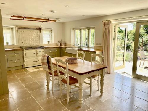 a large kitchen with a wooden table and chairs at Meadow Cottage in Hampshire's Test Valley in Andover