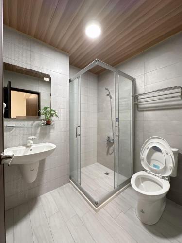 a bathroom with a shower and a toilet and a sink at 18 Walking Homestay in Fangliao