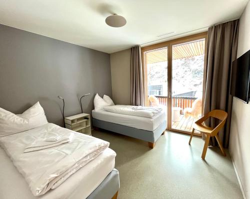 a hotel room with two beds and a balcony at Ferienwohnung Stenna SELVA direkt bei Bergbahnen Skipiste in Flims