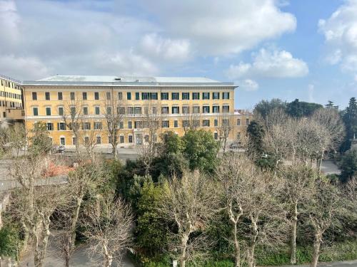 ein großes gelbes Gebäude mit Bäumen davor in der Unterkunft Appartamento La Fenice in Genua
