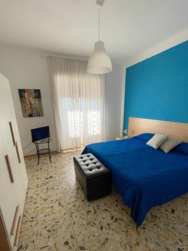 um quarto azul com uma cama e uma cadeira em B&B A casa mia em Moio della Civitella