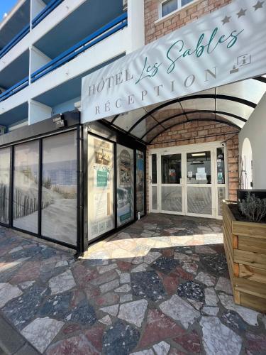 a store front of a building with windows at Hôtel Les Sables - Urban Style - by Logis Hotels in Canet-en-Roussillon