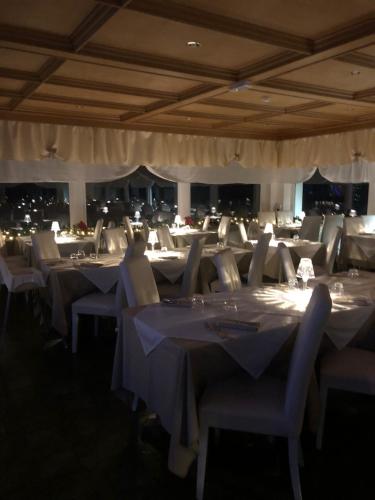 a dining room with white tables and chairs at Naturhotel Wieserhof in Longostagno