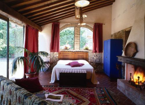 1 dormitorio con 1 cama en una habitación con chimenea en Agriturismo & Winery Il Bacio, en Tavarnelle in Val di Pesa