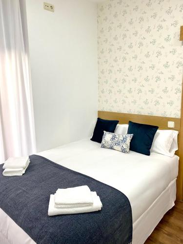 een slaapkamer met 2 bedden en handdoeken bij Apartamentos Fuencarral II in Madrid