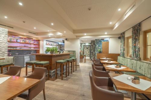 a restaurant with wooden tables and chairs at Ferienhotel Jörglerhof in Hainzenberg