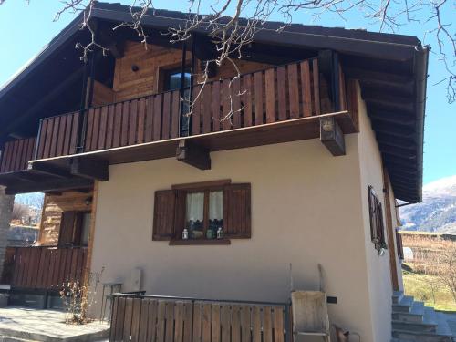 a house with a balcony and windows and stairs at A casa da Elide in Aymavilles