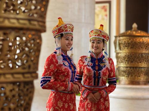 two women in traditional chinese clothing standing next to each other at Shangri-La Huhhot in Hohhot