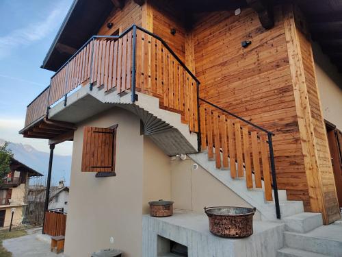 a house with wooden stairs on the side of it at A casa da Elide in Aymavilles