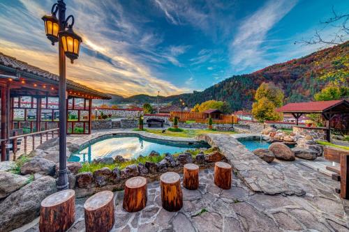 a home with a pool with logs around it at Хотел Смолена in Smilyan