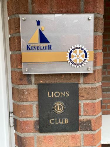 a sign for the lions club on a brick wall at Hotel zur Brücke in Kevelaer