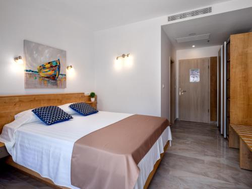 a bedroom with a large bed with blue pillows at D-Elegant Lapad Dubrovnik in Dubrovnik