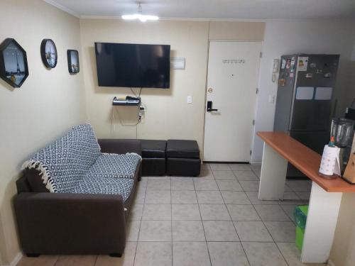 a living room with a couch and a flat screen tv at Acogedor depto al sur de Chile buena accesibilidad in Puerto Montt