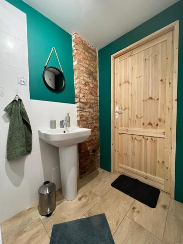 a bathroom with a sink and a wooden door at Siedlisko Barycz Kolonia, Dom całoroczny na wyłączność - 50 m2 6 osobowy z 2 pokojami, teren 2 hektary wśród lasów i łąk in Zwoleń