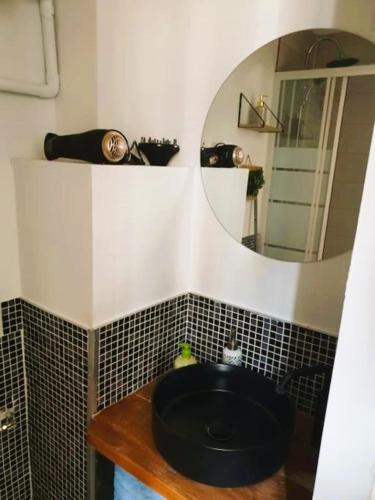 une salle de bain avec un lavabo noir et un miroir dans l'établissement STUDIO LE PETIT ATELIER - PROCHE GARE - WiFi, à Amiens