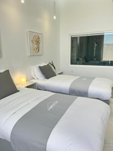 twee bedden in een kamer met een groot raam bij غيمة مصفوت 