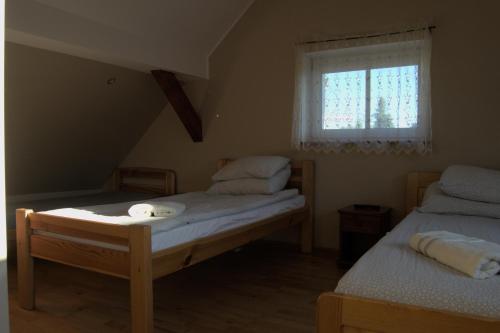 a bedroom with two twin beds and a window at U Rybaka in Braniewo