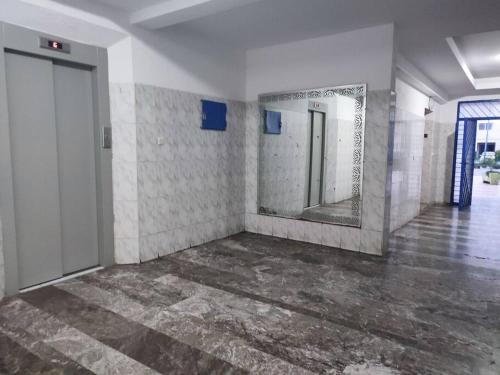 une pièce vide avec un miroir et un couloir dans l'établissement Appartement centre-ville agadir, à Agadir