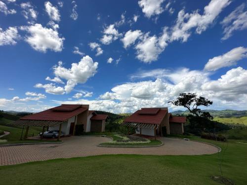 a house with a car parked next to a driveway at Lavandas de Cunha Pousada Boutique in Cunha