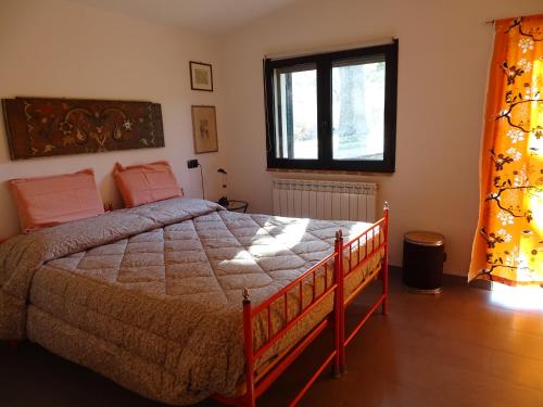 um quarto com uma cama grande e uma janela em Podere Travagliola em Castiglione dʼOrcia