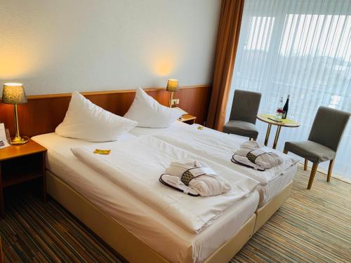 a hotel room with a bed with towels on it at Mercure Hotel Riesa Dresden Elbland in Riesa